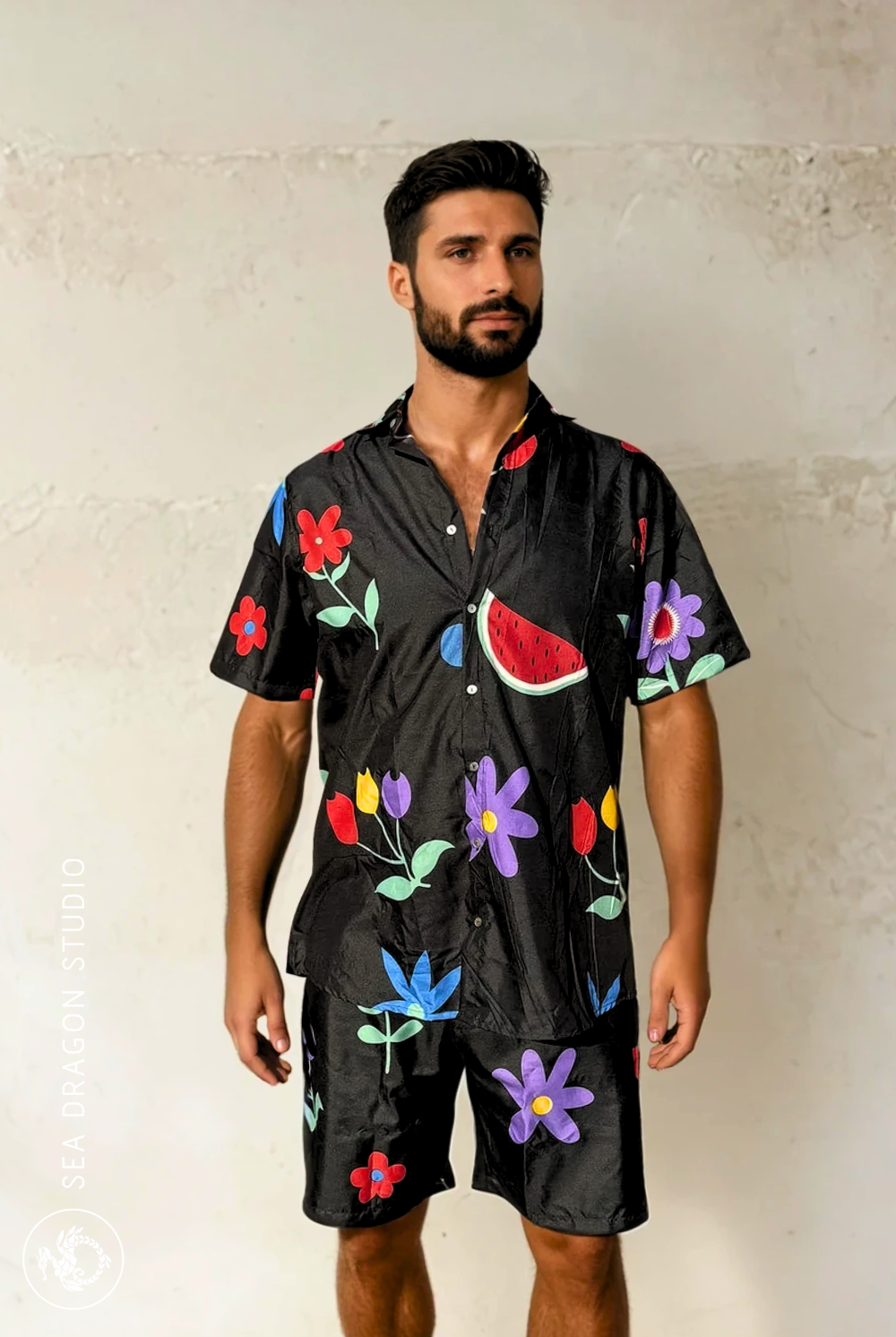 Model wearing the Midnight Picnic shirt and shorts set, side view showing floral-and-fruit print.