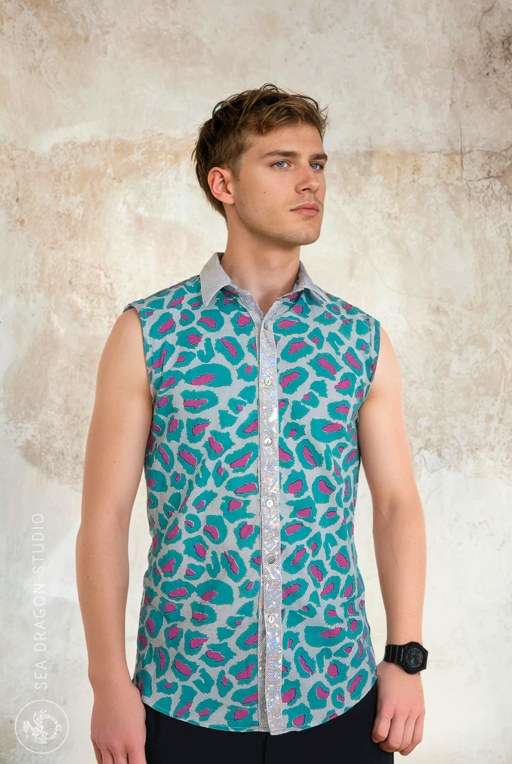 Model wearing the Sea Dragon Studio Tecno Tiger sleeveless shirt in teal and magenta animal print, a lightweight festival and party-ready piece.