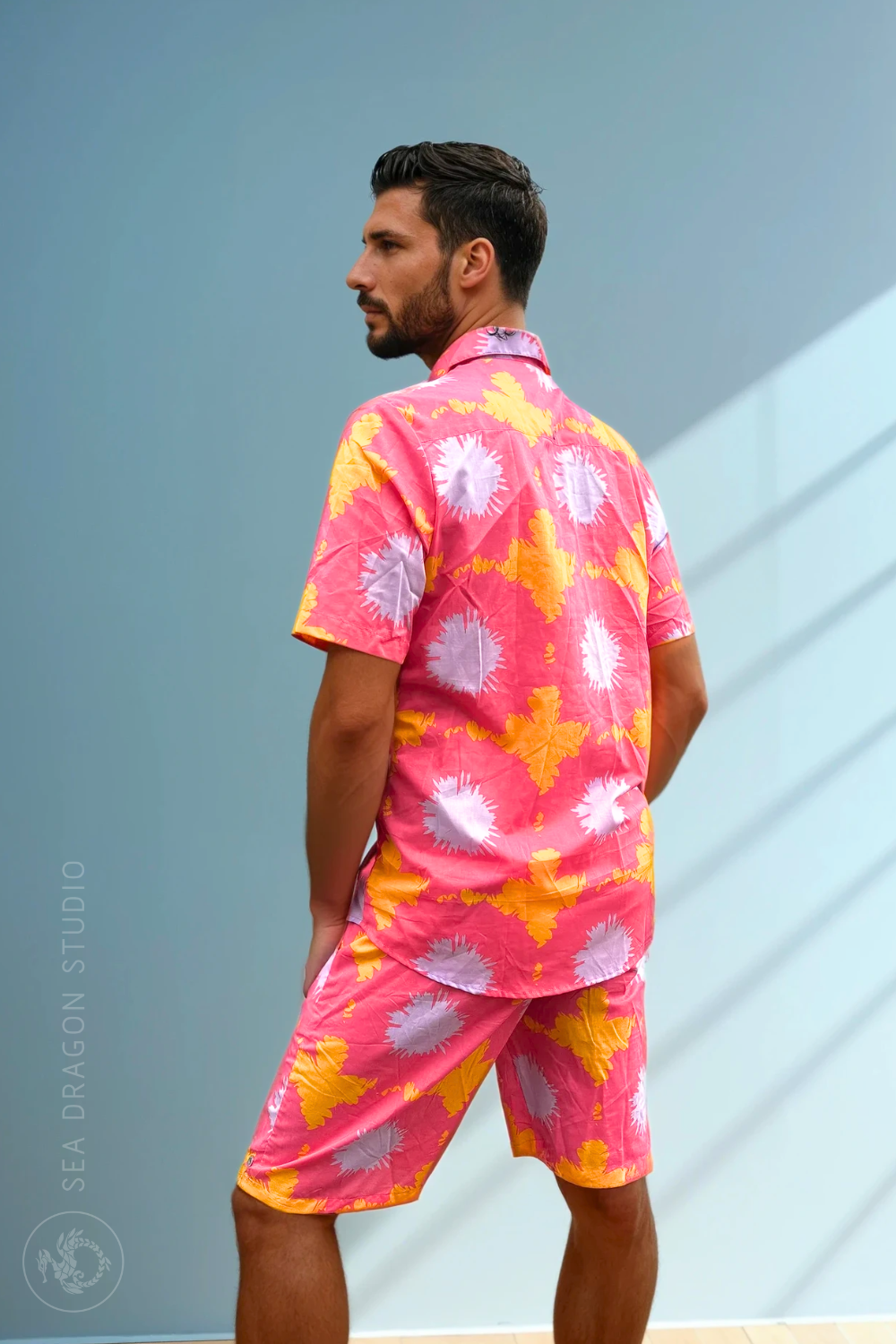 Side view of the Tropic Drift pink cotton shorts on the model, showing the relaxed summer fit.