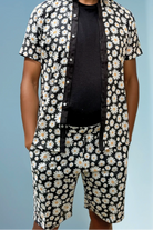 Sea Dragon Studio Daisy Cutter Shorts with black base and white daisy print, featuring a relaxed mid-thigh summer fit.