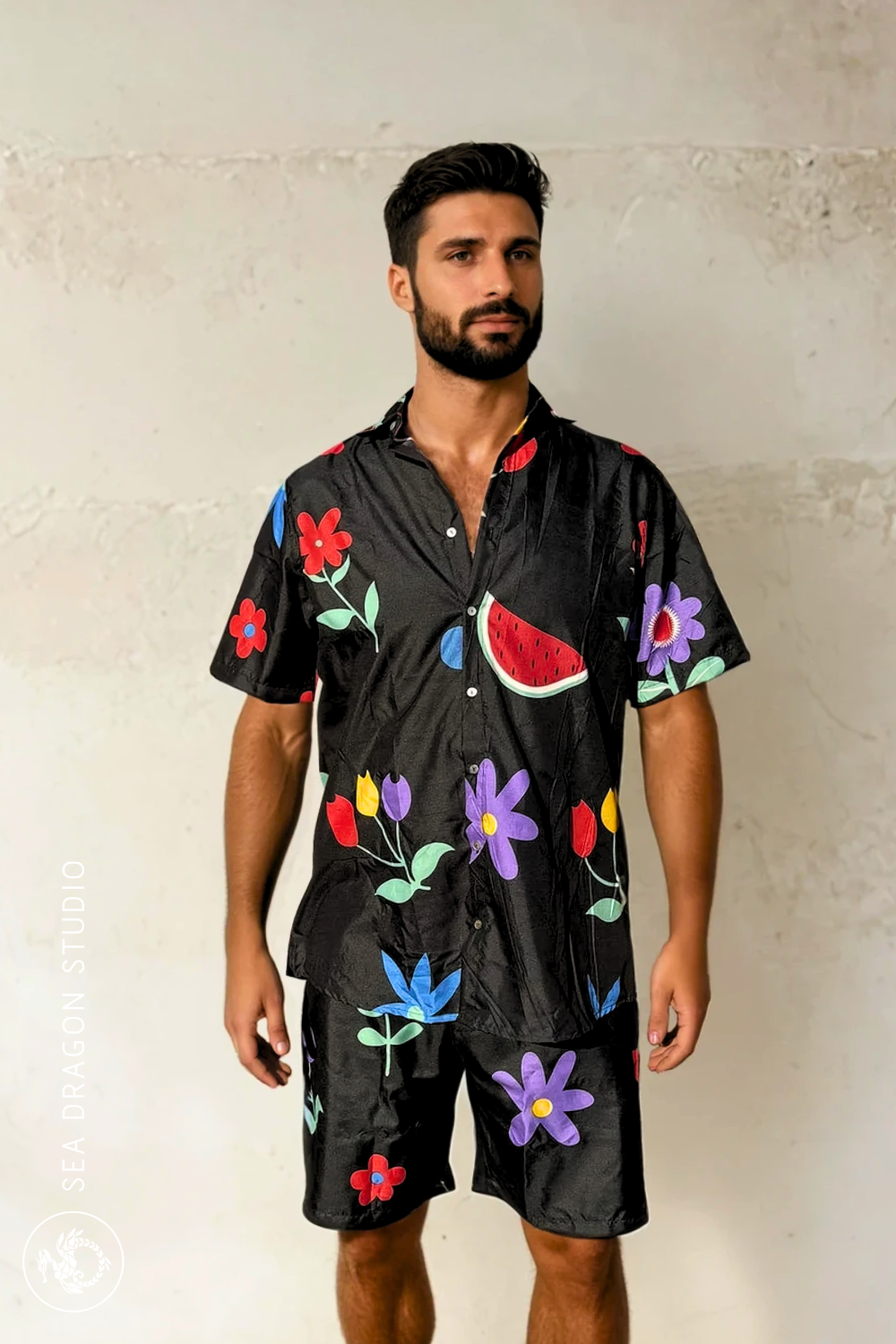Model wearing the Midnight Picnic shirt and shorts set, side view showing floral-and-fruit print.